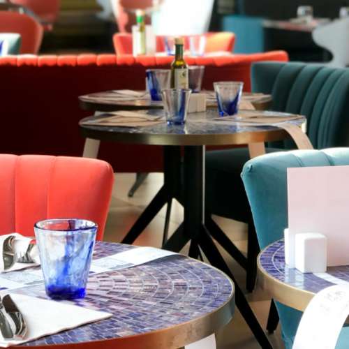 Ambiance de la salle d’Il Ristorante Marquette-lez-Lille : tables rondes et fauteuils colorés, photo de la fiche du restaurant sur TheFork.